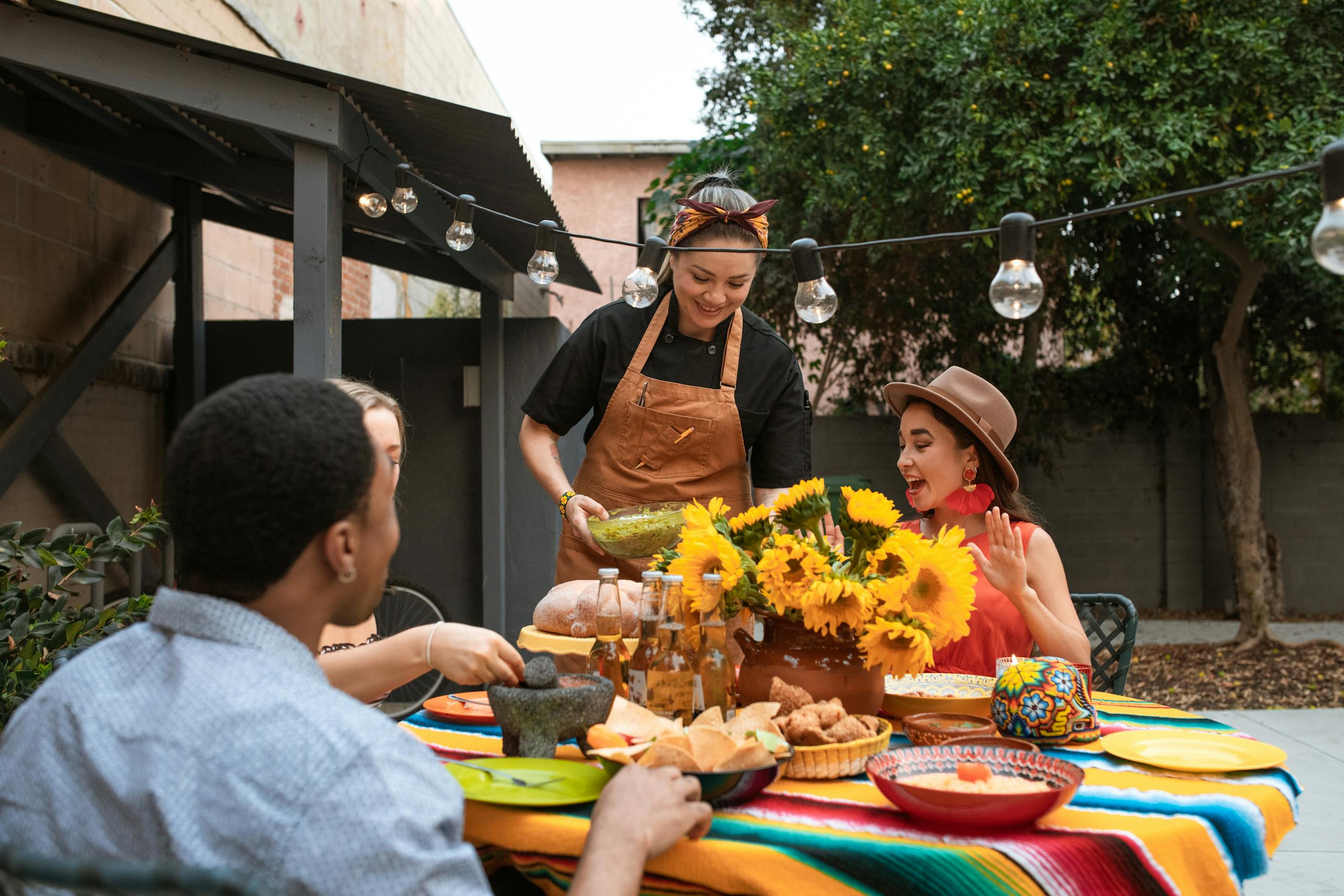 A joyous gathering with Mexican food and festive decorations outdoors, ideal for Cinco de Mayo.