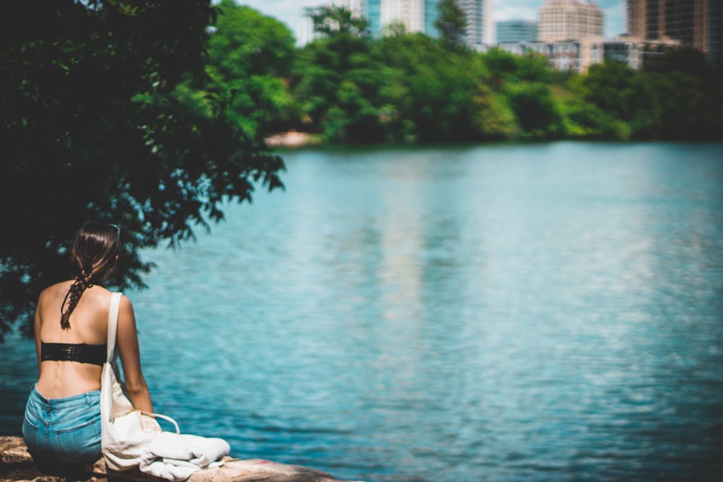 A woman enjoys a sunny day by the serene Lady Bird Lake in Austin, Texas.